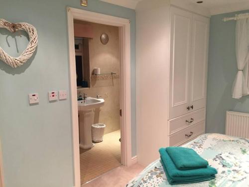 1 dormitorio con 1 cama y baño con lavamanos en The Bungalow, en Preston