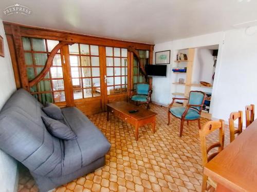 un salon avec un canapé, une table et des chaises dans l'établissement Ferme de ma Grand-Mère, à Le Haut-du-Them