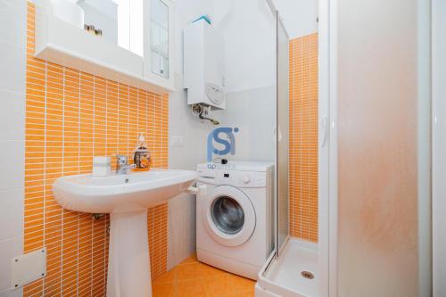 ein Badezimmer mit einer Waschmaschine und einem Waschbecken in der Unterkunft Ni Ni Apartments - Self Check in in Cefalú