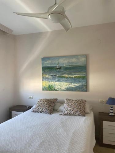 a bedroom with a bed with a painting on the wall at Piso primera línea, Banana Beach, Marbella. in Marbella