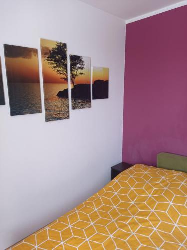 a bedroom with four paintings of a tree on the wall at Apartament do wynajęcia in Olecko