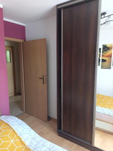 a bedroom with a large wooden closet and a bed at Apartament do wynajęcia in Olecko
