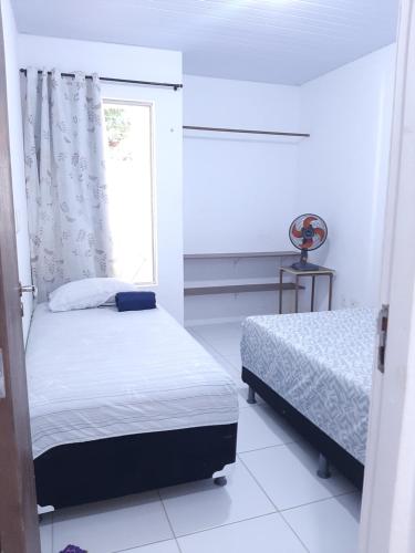 a bedroom with two beds and a window at Cantinho arretado da Peste - Apartamento in Aquiraz