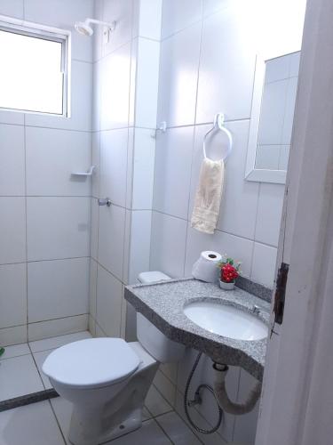 a white bathroom with a toilet and a sink at Cantinho arretado da Peste - Apartamento in Aquiraz
