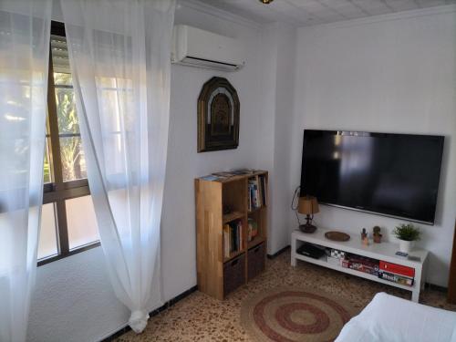 a living room with a flat screen tv next to a window at Piso Centro María Aire-Wifi in Elche