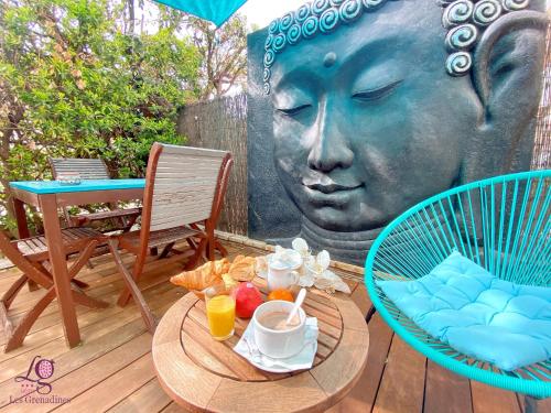 a table with a statue of a woman with a head at Logis Hôtel Les Grenadines in Cap d'Agde