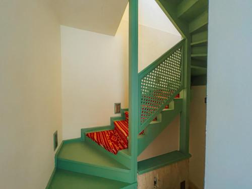a staircase in a house with a green stair case at Riad Lalla Mimouna in Marrakech