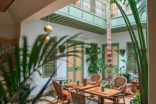 a restaurant with wooden tables and chairs and plants at Riad Lalla Mimouna in Marrakech