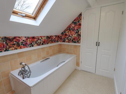a bathroom with a bath tub and a window at North Lodge in Grasmere