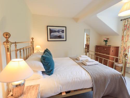 a bedroom with a bed with a lamp and a table at Holmdale in Ambleside