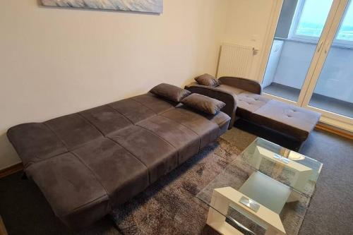 a living room with a brown leather couch and a table at Apartman Mima in Zagreb
