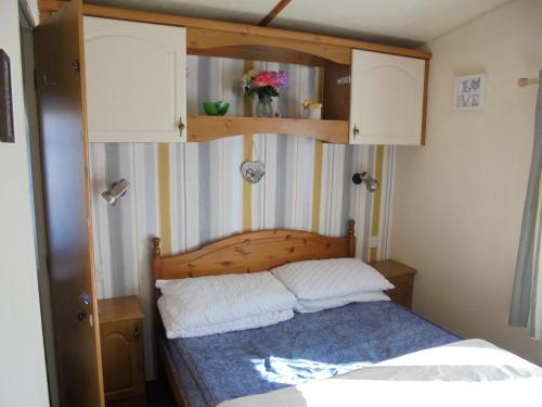 a bedroom with a bed with a wooden headboard at 6 Berth central heated on The Chase (Brentmere) in Ingoldmells