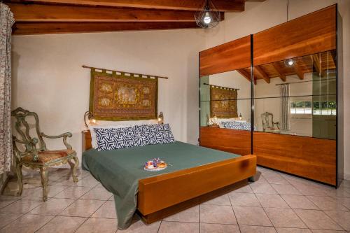 カステッランマーレ・デル・ゴルフォにあるVilla Gagliardettaのベッドルーム1室(ベッド1台、椅子1脚付)