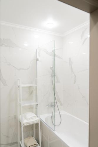 a white bathroom with a shower and a tub at 71 East Hotel in Astana