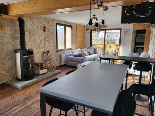 un salon avec une table et une cheminée dans l'établissement Maison de moyenne montagne baignée par le soleil, à La Côte-dʼAime