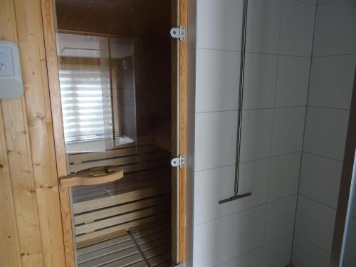 a shower with a glass door in a bathroom at Kustverhuur, Dorpswoning Breskens, Boulevard 15 in Breskens