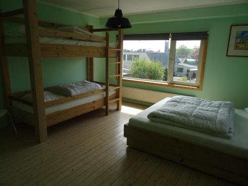 a bedroom with two bunk beds and a window at Kustverhuur, Dorpswoning Breskens, Boulevard 15 in Breskens