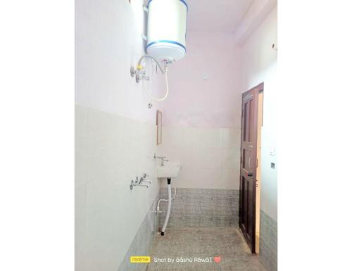 uma casa de banho com um lavatório e uma luz na parede em AK resort, Barkot em Barkot