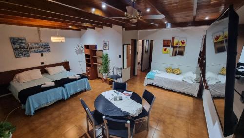 a room with two beds and a table and chairs at departamento temporario de 1 a 4 personas in Posadas