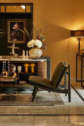 a living room with a chair and a table at Rephael House Boutique Hotel in Rishon LeẔiyyon