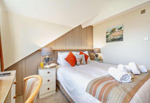 a bedroom with two beds and a desk with a chair at Lion Hotel & Studio Apartments in Criccieth