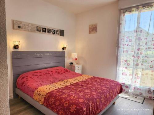 une chambre avec un lit avec une couverture rouge et une fenêtre dans l'établissement Bel F3 en résidence avec piscine, baignoire balnéo, à Touques