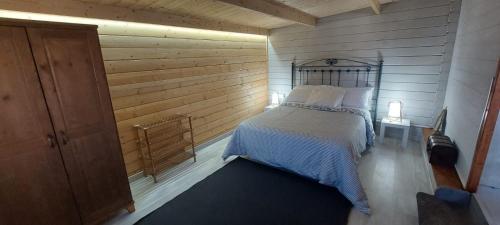 1 dormitorio con 1 cama en una pared de madera en Villa Los Guirres, en Tazacorte