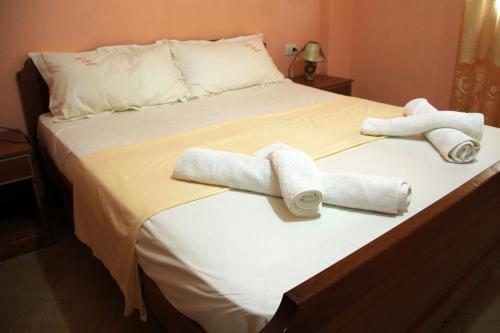 a bed with two rolled towels on it at King's Star Hotel in Velipojë