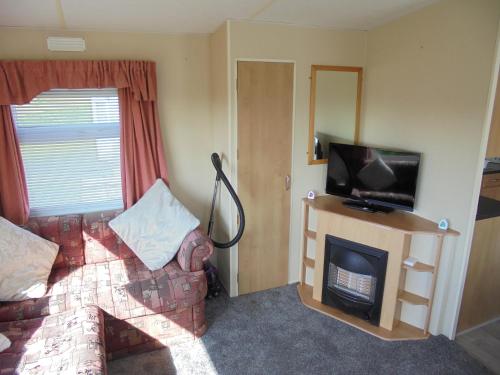 a living room with a couch and a fireplace at 6 Berth heated on The Chase (Albany II) in Skegness