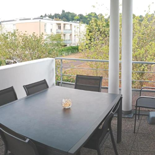 a black table and chairs on a balcony at Chambre #3 dans appartement partagé - Proche des Vosges in Thann