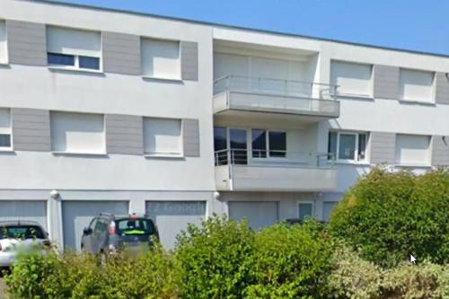 a white building with a car parked in front of it at Chambre #3 dans appartement partagé - Proche des Vosges in Thann