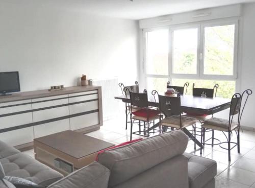 a living room with a couch and a table with chairs at Chambre #3 dans appartement partagé - Proche des Vosges in Thann