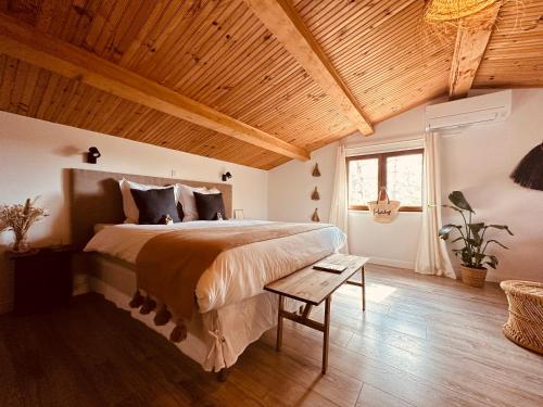 a bedroom with a large bed and a wooden ceiling at 4 Saisons en Provence in Saint-Paul-en-Forêt