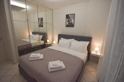 a bedroom with a large bed with two towels on it at K&C Rooms- Apartments in Markopoulo