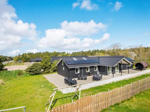 uma casa preta com painéis solares em 16 person holiday home in R m em Rømø Kirkeby