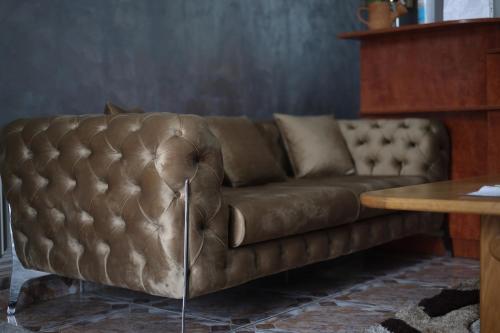 un sofá de cuero marrón en una sala de estar con mesa en Hotel Casa Italia en Calafat