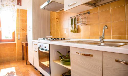 a kitchen with a sink and a stove at Casa Baddò, fronte spiaggia A/C in Cala Gonone