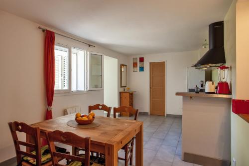 une cuisine avec une table avec un bol de fruits dessus dans l'établissement Casa Les Oliviers, à Santa-Maria-di-Lota