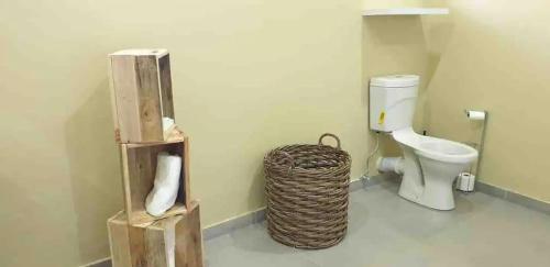 a bathroom with a toilet and a basket at Ultra modern 2 bedroomed apartment - 2082 in Bulawayo