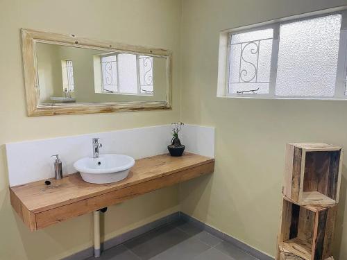 a bathroom with a sink and a mirror at Ultra modern 2 bedroomed apartment - 2082 in Bulawayo