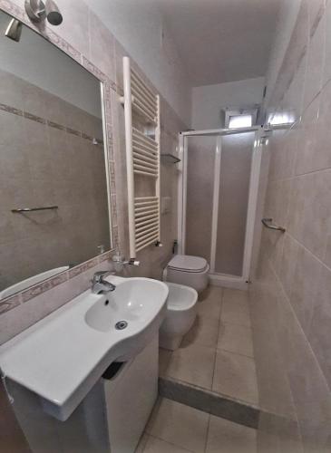 a white bathroom with a sink and a toilet at La Nchioscia in La Spezia