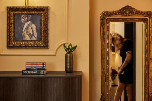 a woman standing in front of a mirror at Rephael House Boutique Hotel in Rishon LeẔiyyon