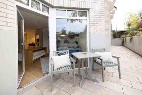 a patio with a table and chairs on a balcony at ArtRoom Boarding Apartment in Bissendorf