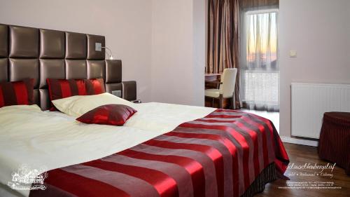 een slaapkamer met een groot bed en een gestreepte deken bij Hotel-Restaurant Schmachtenbergshof in Essen