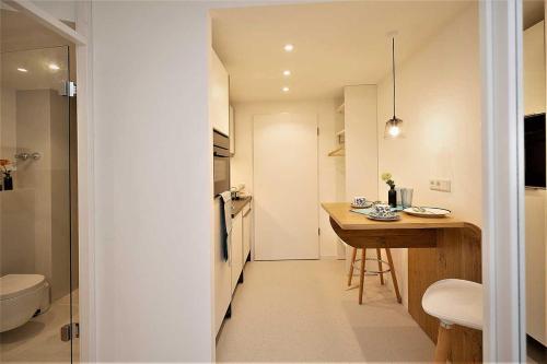 uma pequena cozinha com uma mesa e um lavatório em ArtRoom Boarding Apartment em Bissendorf
