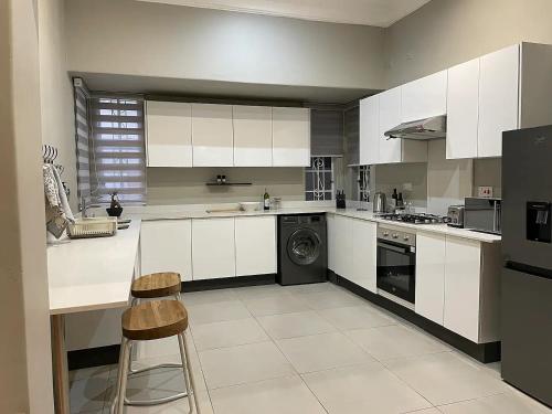 Modern Apartment - 2081 في بولاوايو: مطبخ كبير مع دواليب بيضاء وغسالة صحون