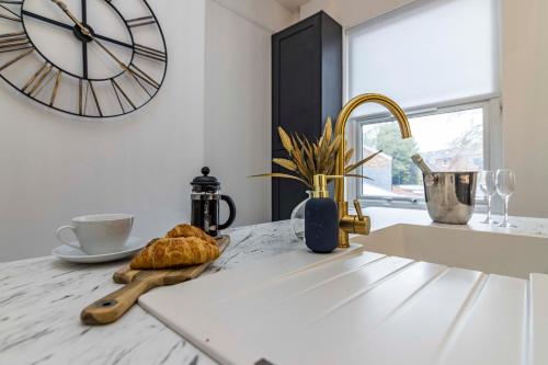 a kitchen counter with a clock on the wall and a sink at 3 bed house sleeps 6 walking distance in to Nottingham city centre ideal for contractors and corporate travellers in Nottingham