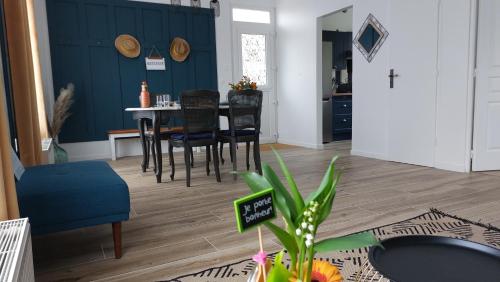a living room with a table and chairs and a plant at La Coccinelle, votre Oasis entre Paris-Disney in Ozoir-la-Ferrière
