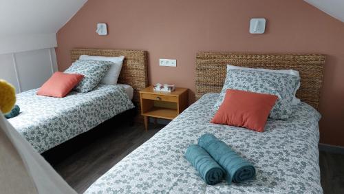 una camera con due letti con cuscini sopra di La Coccinelle a Ozoir-la-Ferrière
