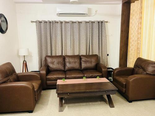 維沙卡帕特南的住宿－Vyasams Happy Nest，客厅配有两张真皮沙发和一张茶几